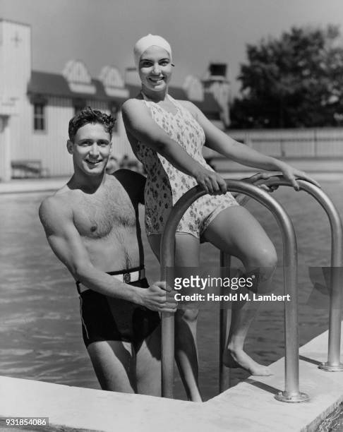 Portrait of couple standing besides swimming pool
