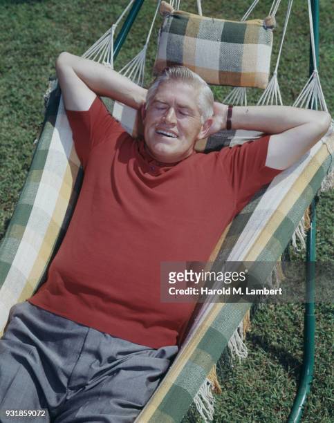 Senior man resting on hammock, smiling