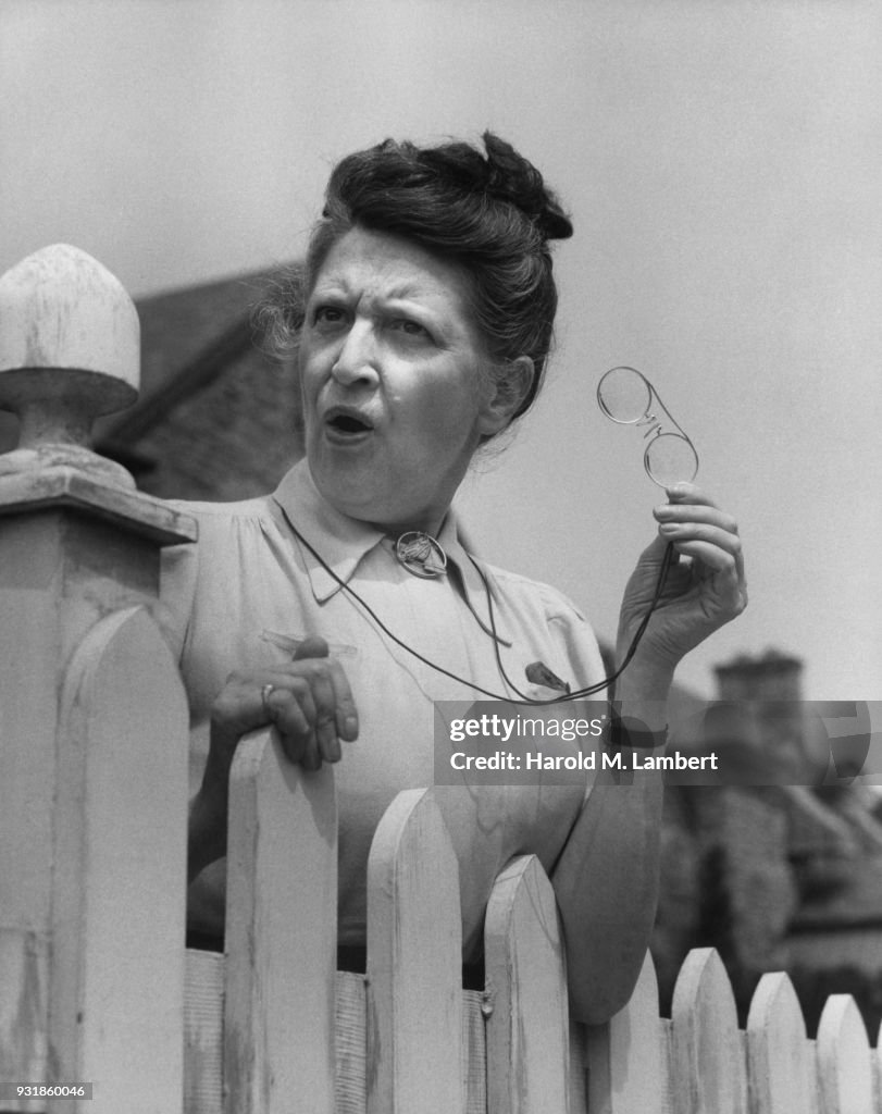 Senior woman standing near fence