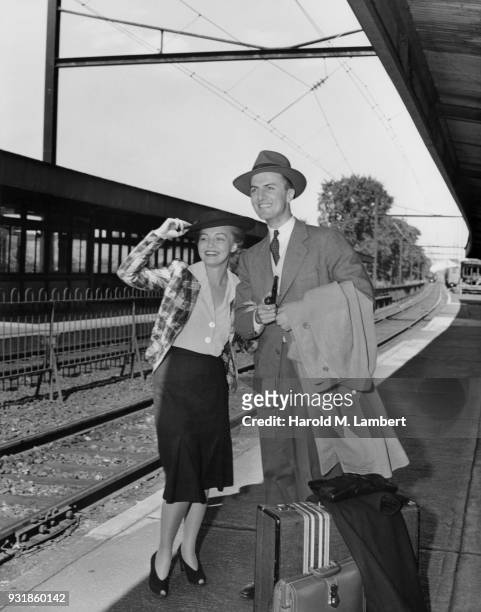 Couple waiting for train at railroad station platform