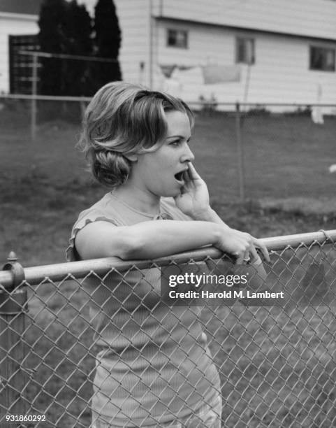 Shocked woman standing besides fence