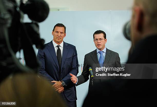 German Minister of Defense Karl Theodor zu Guttenberg gestures as he speeks to the media together with actor Ralf Moeller at Bendlerblock on November...