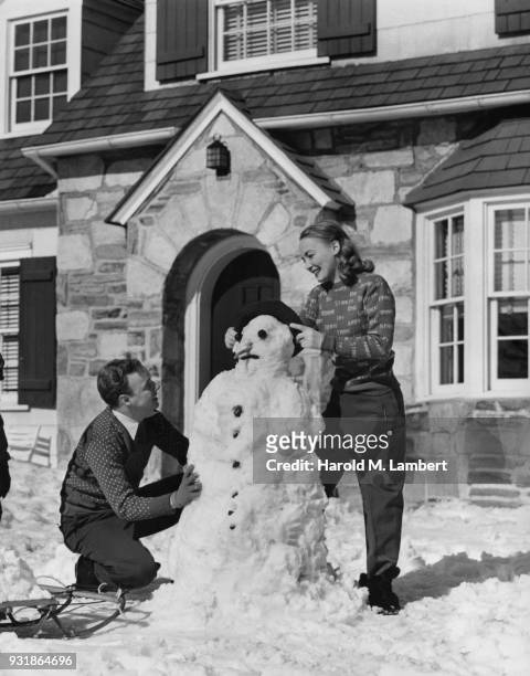Young couple making snowman