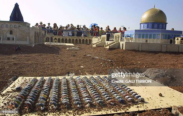 Tourists looks at a model of Jerusalem's Al-Aqsa mosques compound with figurines representing Muslims during prayer, which is part of Mini-Israel, a...