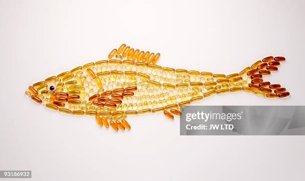 capsules in shape of fish - fish oil foto e immagini stock