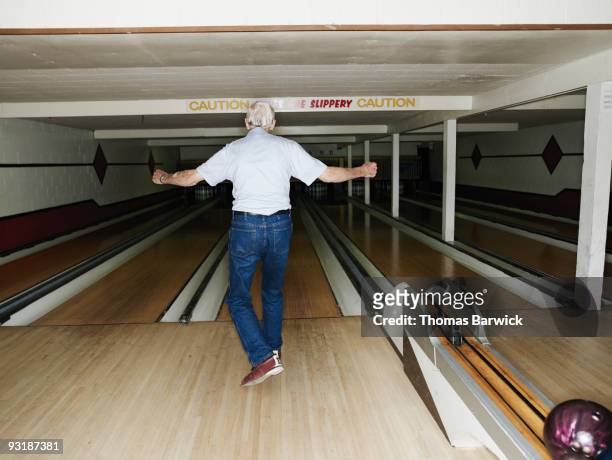 mature man celebrating after bowling rearview  - senior men bowling stock pictures, royalty-free photos & images