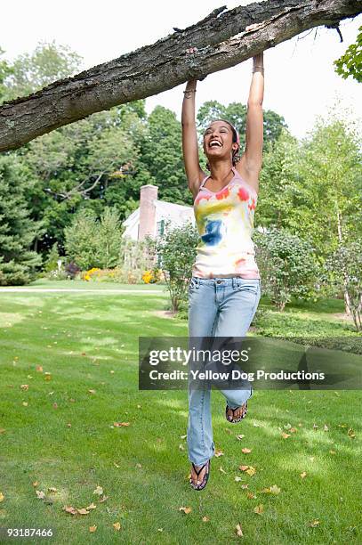 teen girl hanging from tree limb - manchester vermont foto e immagini stock