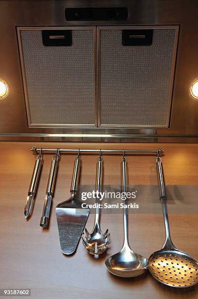 cooking utensils hanging from hooks in kitchen - espátula de servir bolo imagens e fotografias de stock