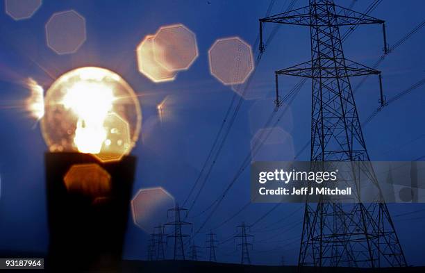 In this photo illustration an incandescent light bulb is illuminated next to electricity pylons on November 18, 2009 in Greenock, Scotland. As world...