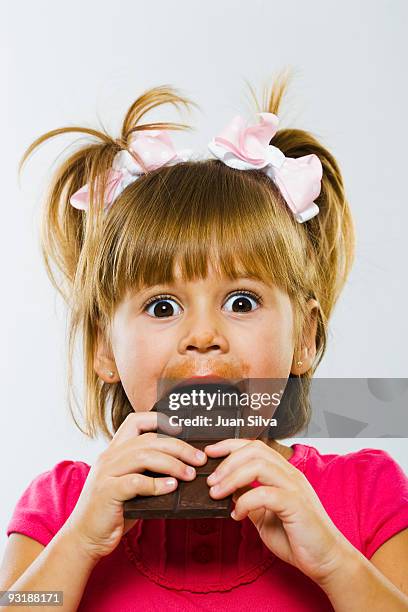 girl eating chocolate bar with eyes wide open - open chocolate bar stock pictures, royalty-free photos & images