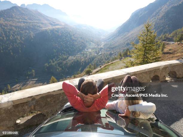 couple lean on car hood, look towards distant mtns - car hood stock pictures, royalty-free photos & images