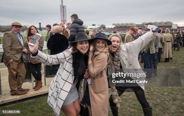 Racegoers gather to watch the first raced of the day on Ladies Day at the Cheltenham Racecourse on March 14, 2018 in Cheltenham, England. Thousands...