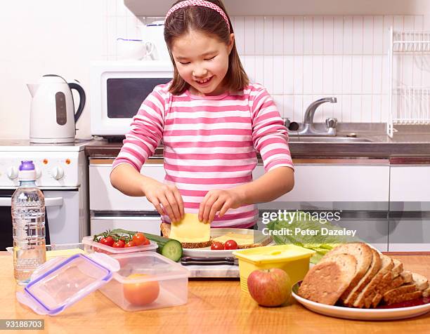 9 year old school girl making healthy lunch box. - parsons green foto e immagini stock