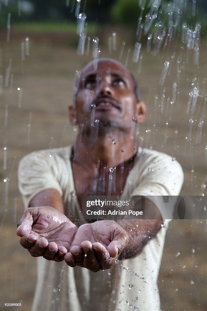Indian farmer feeling monsoon rain