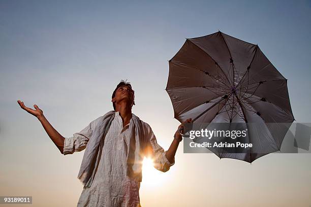 farmer sheltering from sun hoping for monsoon rain - umbrella sun stock-fotos und bilder