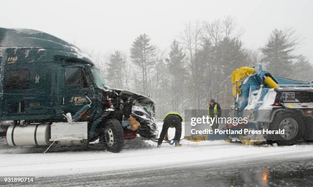 Worker hooks a tow truck to a tractor trailer that got stuck in the median of the Maine Turnpike in Wells on Tuesday, March 13, 2018.