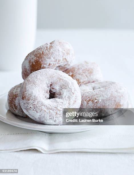 powdered sugar donuts on white tablecloth - puderzucker stock-fotos und bilder