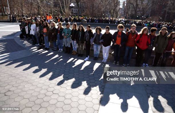 Students from Harvest Collegiate High School form a circle around the fountain in Washington Square Park on March 14, 2018 in New York to take part...