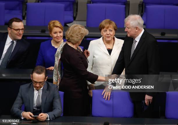 German Chancellor Angela Merkel and ministers of Germany's new government look on as German Interior Minister Horst Seehofer talks with the Federal...