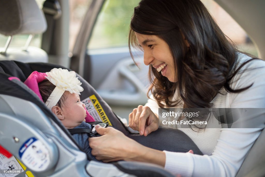 Mom Buckling Infant Into Car Seat