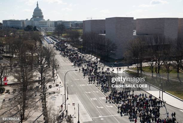 Thousands of local students march down Pennsylvania Avenue to the US Capitol during a nationwide student walkout for gun control in Washington, DC,...