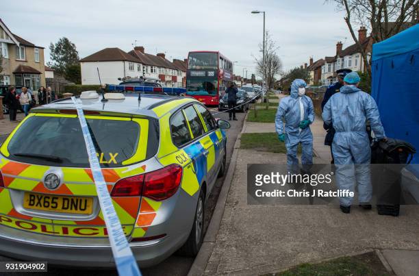 Two police forensics officers prepare to enter a police tent outside the home of Russian exile Nikolai Glushkov who was found dead at his home in New...