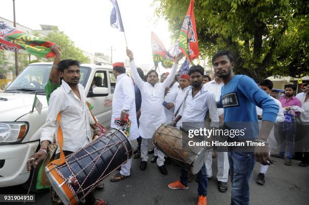 Samajwadi Party workers along with BSP members celebrate after winning the Lok Sabha election seats in Uttar Pradesh, on March 14, 2018 in Noida,...