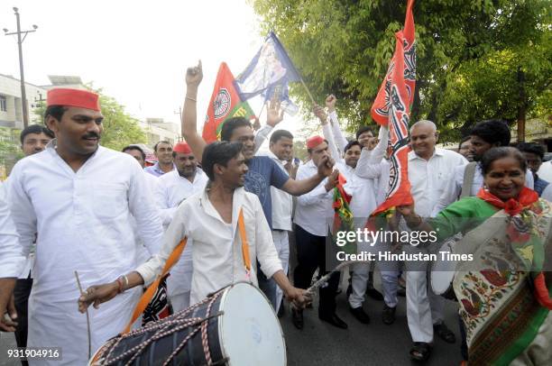 Samajwadi Party workers along with BSP members celebrate after winning the Lok Sabha election seats in Uttar Pradesh, on March 14, 2018 in Noida,...