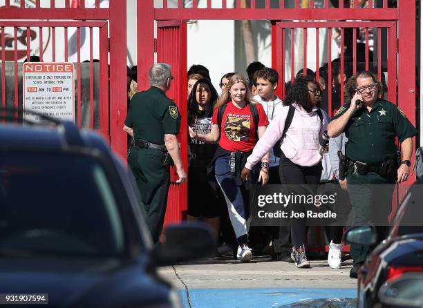 Students from Marjory Stoneman Douglas High School walk out of school to honor the memories of 17 classmates that were killed during a mass shooting...