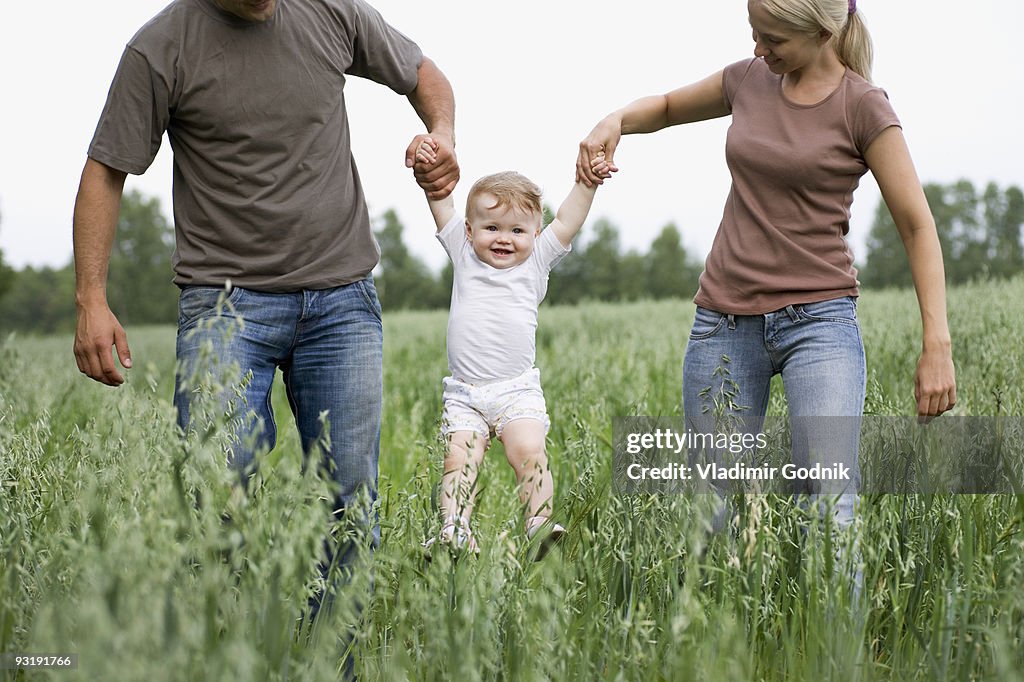 Two parents lifting a child in the air