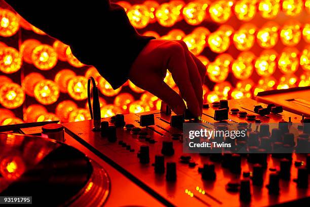 a dj adjusting levels on a sound mixer at a nightclub - dj mixer stock pictures, royalty-free photos & images