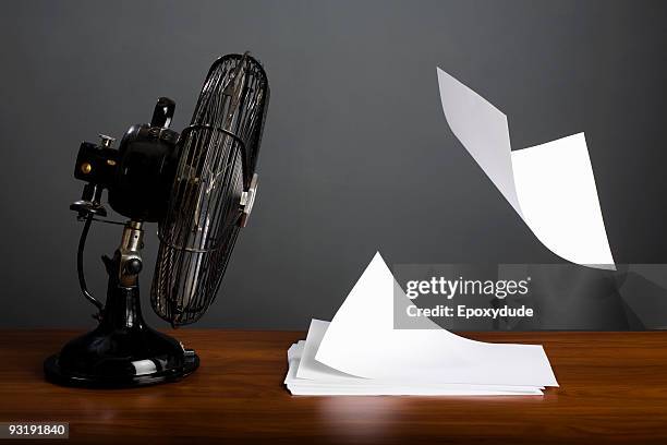 an electric fan blowing a stack of paper - electric fan paper stock pictures, royalty-free photos & images