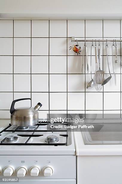 detail of a stove and sink in a kitchen - kitchen wall stock-fotos und bilder