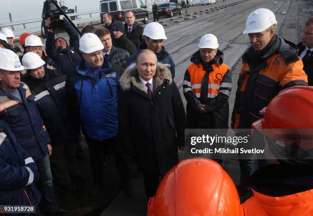 Russian President Vladimir Putin with workers during a visit the construction site for the Crimean bridge which is being built to connect the...