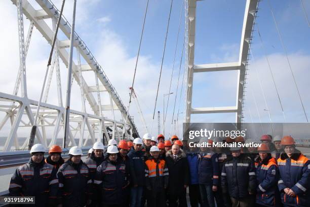 Russian President Vladimir Putin with workers during a visit the construction site for the Crimean bridge which is being built to connect the...