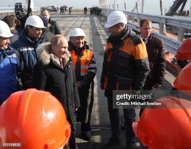 Russian President Vladimir Putin with workers during a visit the construction site for the Crimean bridge which is being built to connect the...