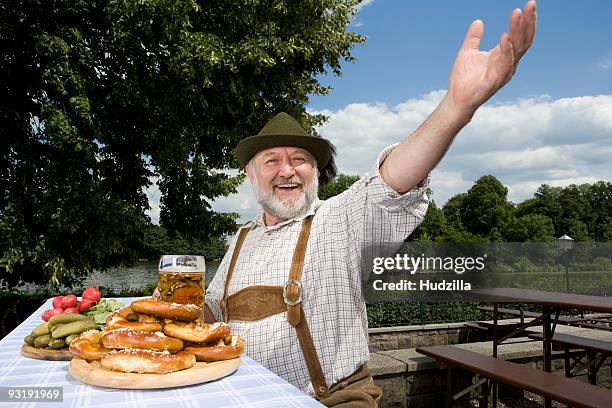 a traditionally clothed german man in a beer garden - biergarten stock-fotos und bilder