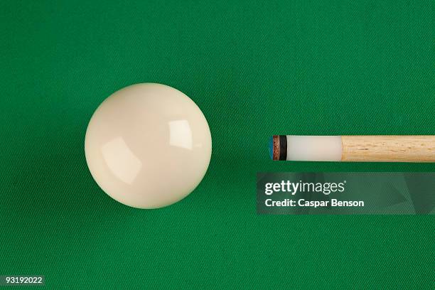 a pool cue and a cue ball on a pool table - billard cue stock-fotos und bilder