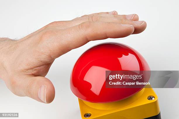 a hand about to press a big red buzzer - button fotografías e imágenes de stock