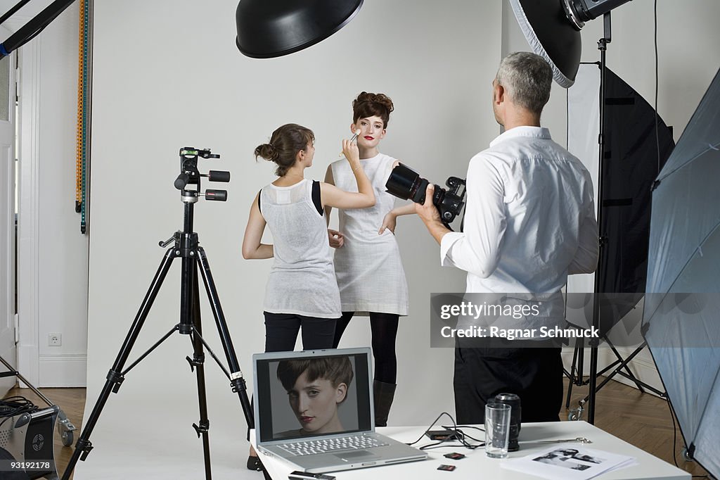 A photographer, model and make-up artist on set of a fashion shoot
