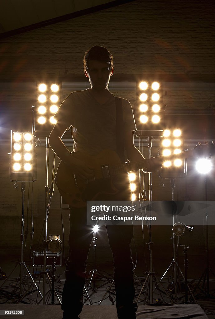 A rock musician playing a guitar on a stage