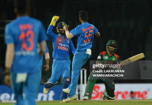 Indian cricketer Washington Sundar celebrates with wicketkeeper Dinesh Karthik after he dismissed Bangladesh cricketer Tamim Iqbal during the fifth...