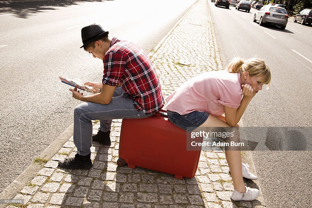 A young couple with a suitcase and a map