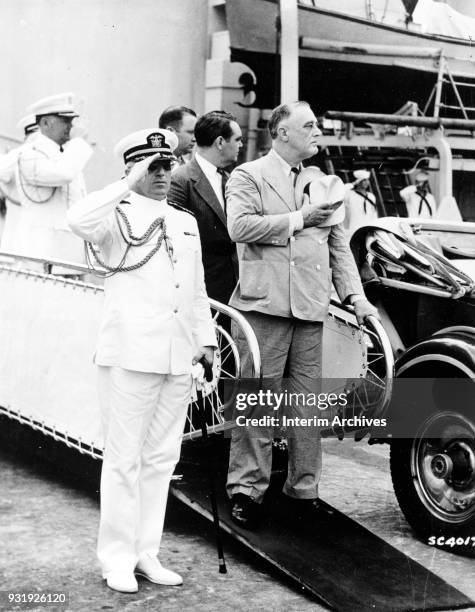 American Naval Aide Captain Daniel J Callaghan and US President Franklin Delano Roosevelt acknowledges the salute of a composite battalion of the...