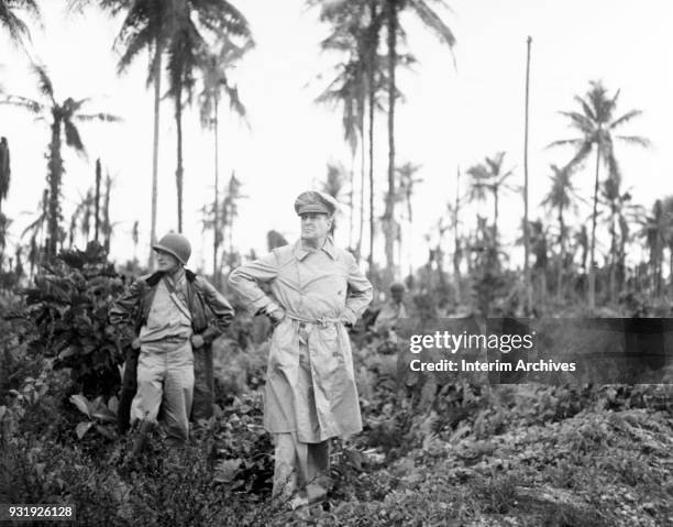 Military commander General Douglas MacArthur and his acting aide Colonel Lloyd Lehrabas inspect the results of the naval bombardment, Los Negros...