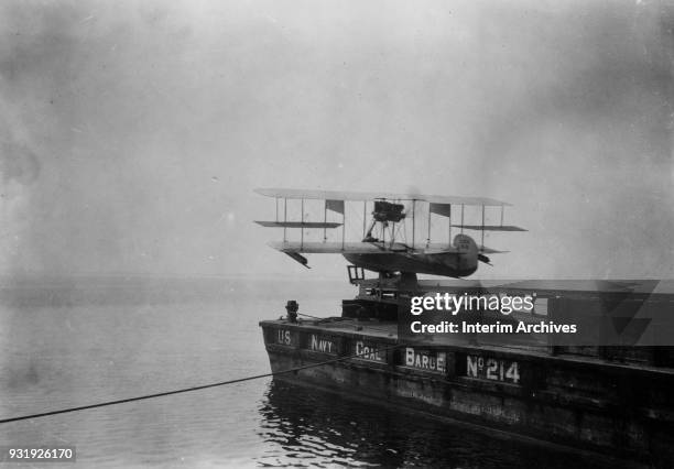 View of a Curtiss C-2 flying boat on the catapult launch of US Navy Coal Barge 214 at Naval Aeronautic Station Pensacola, Pensacola, Florida, early...