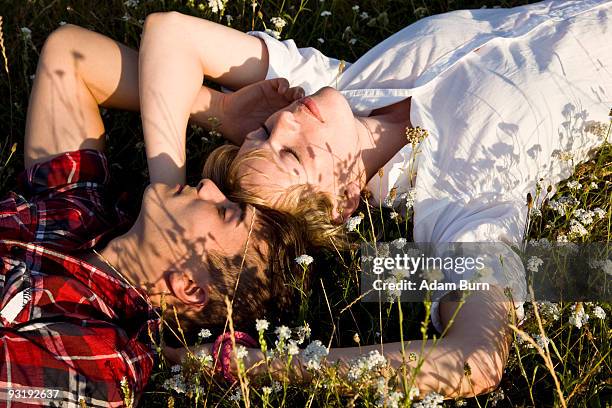 a young couple napping in a field - adam slack stock pictures, royalty-free photos & images