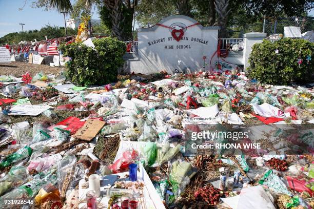 General view of the makeshift memorial in front of Marjory Stoneman Douglas High School as staff, teachers and students walk out of classes to...