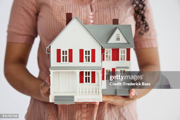 midsection of a woman holding a miniature house - doll house imagens e fotografias de stock