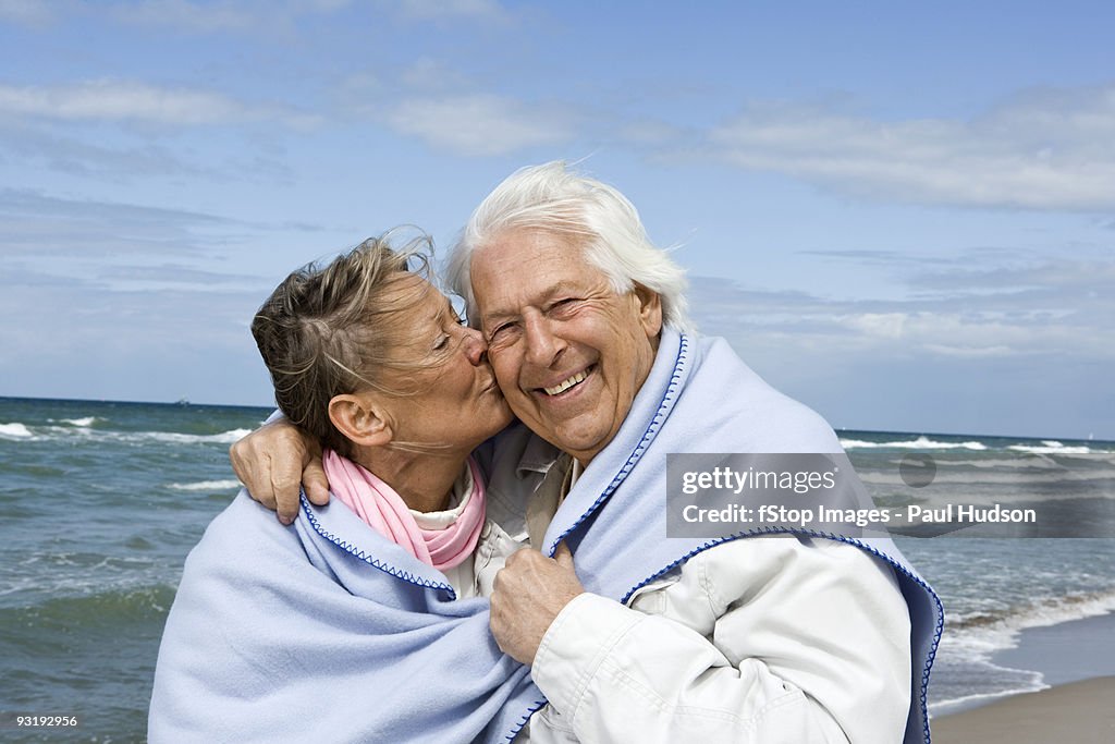 A senior couple walking on a beach together